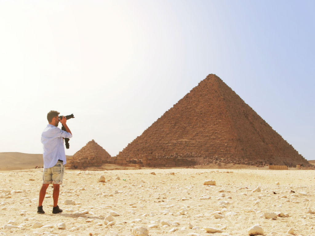  image of man taking photo of pyramid 
