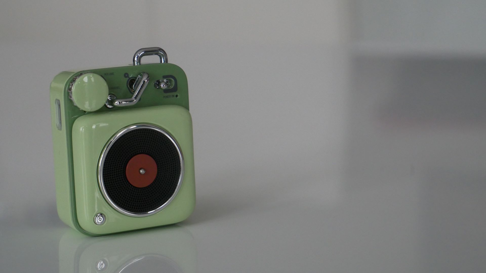 Muzen Button Mini speaker green version on table