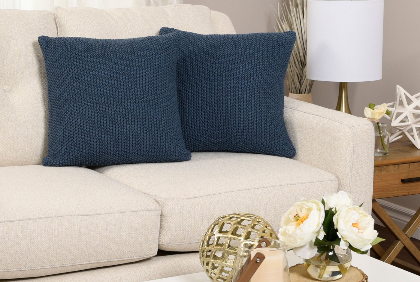 coussins bleu sur un divan beige avec décoration