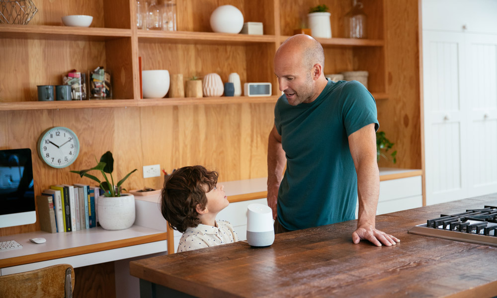 Image of man with kid in kitchen with Google Home Speaker