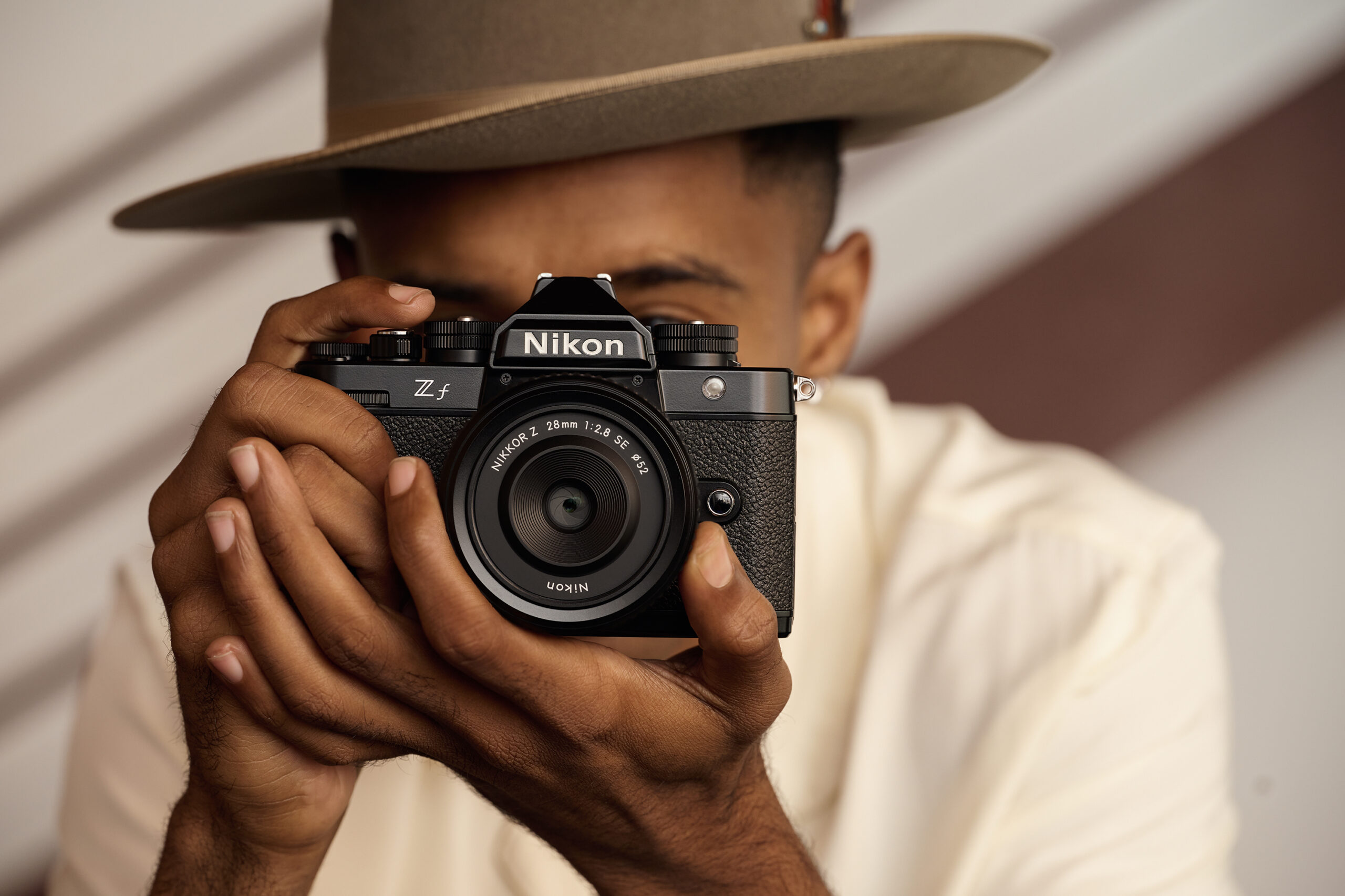 Image of a guy with hat with Nikon Z f camera in hands