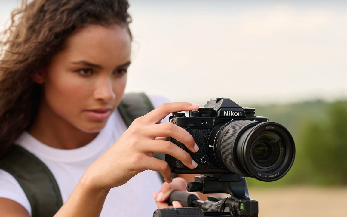 Image of a girl using Nikon Z f camera outside with lens