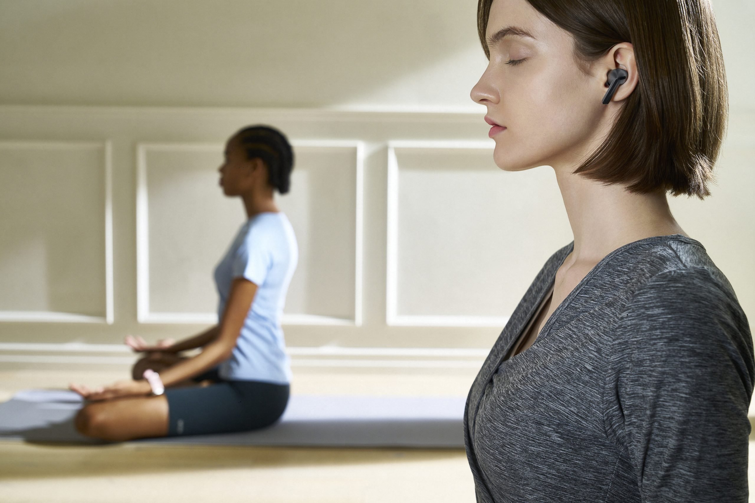 Image d'une femme utilisant des Galaxy Buds3 lors d'un exercice de yoga 