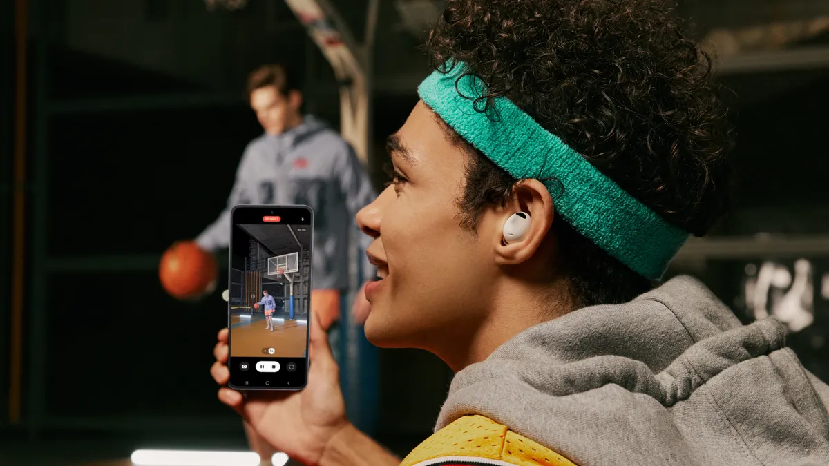 Image of Galaxy Buds2 earbuds with a women and a men on basketball playground