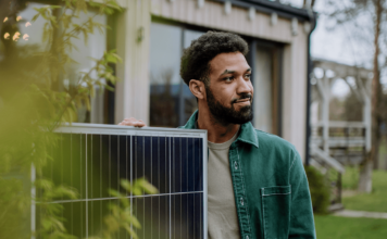 Homme à coté d'un panneau solaire