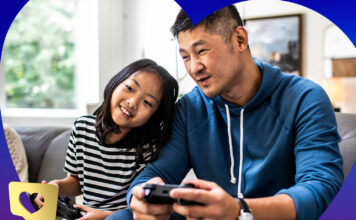 Dad and daugther playing video games together