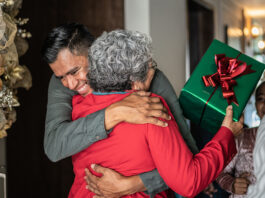 Son greeting mother on christmas at home