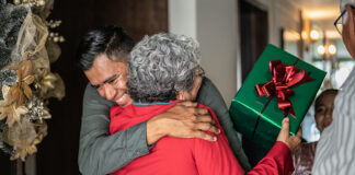 Son greeting mother on christmas at home