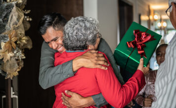 Son greeting mother on christmas at home