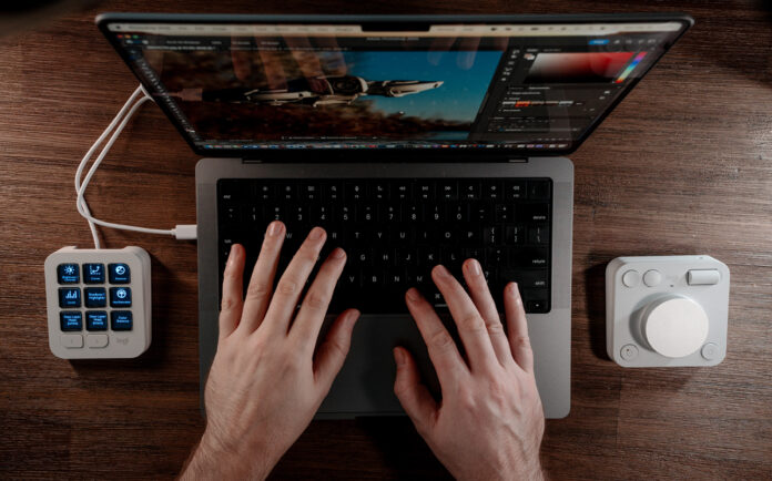 Overhead view of Logitech MX Creative Console flanking a MacBook Pro.