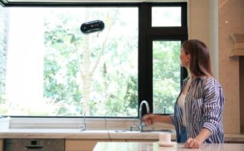Robotic window cleaner cleaning kitchen window.