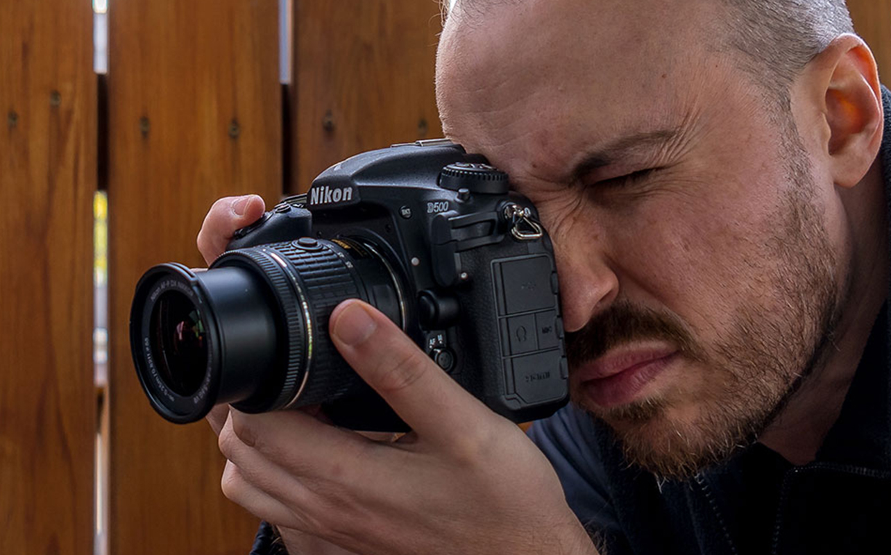 Un photographe prend des photos avec un appareil photo reflex numérique de Nikon