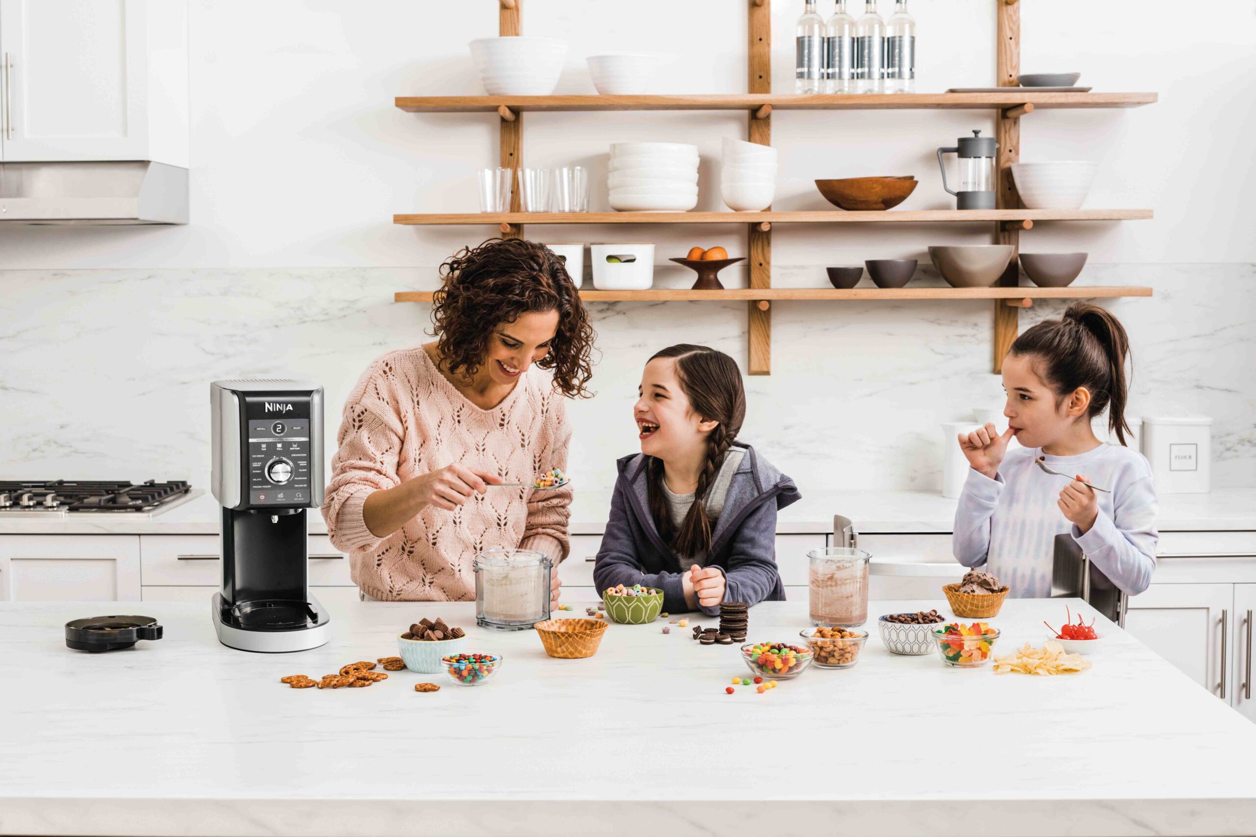 mother and two daughters having fun, making ice cream together with a Ninja ice cream maker.