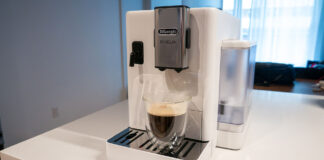 Image de la machine à espresso automatique Rivelia de De'Longhi sur un comptoir de cuisine avec une tasse à café