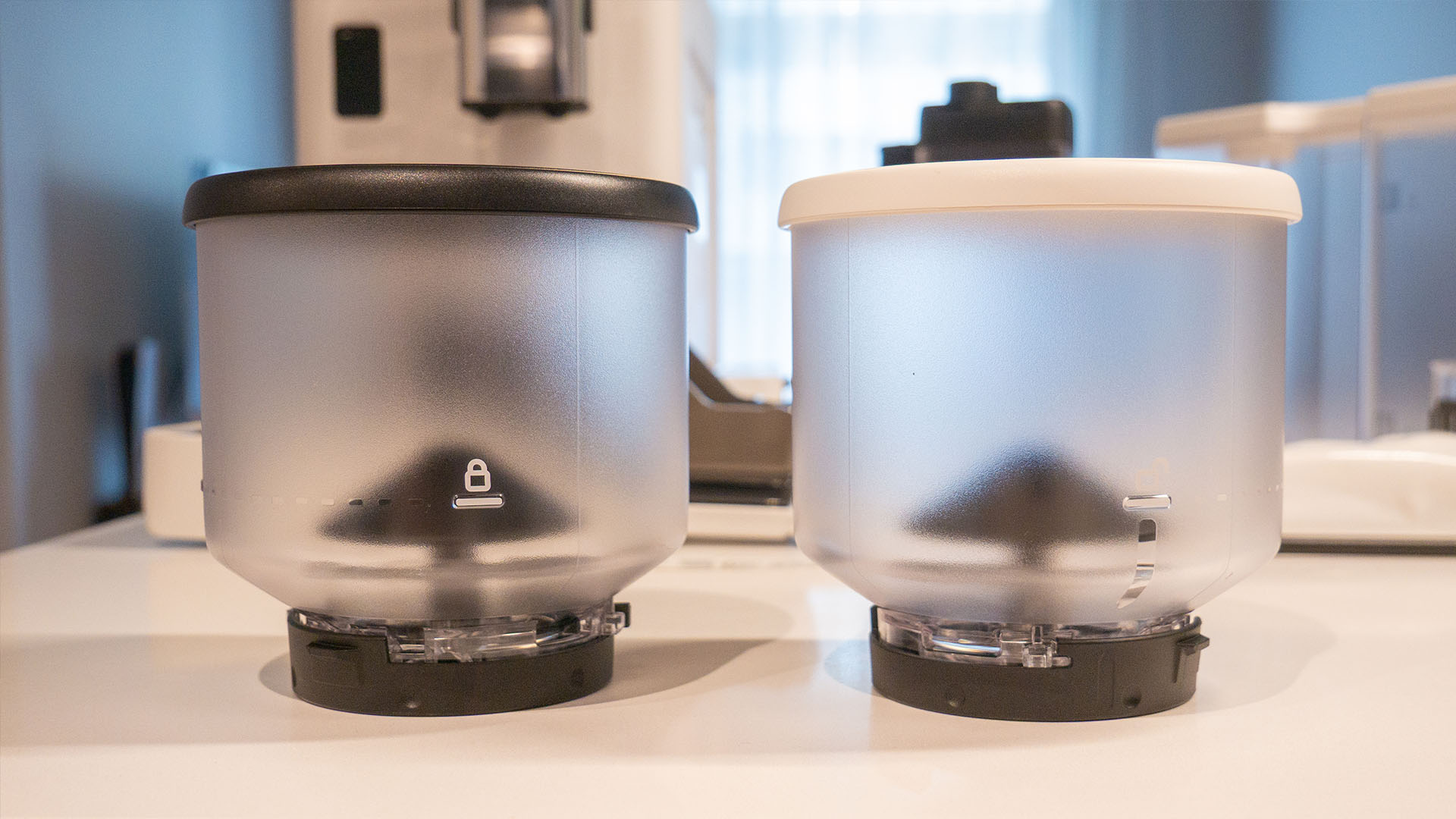 Image des contenants de grains la machine à espresso automatique Rivelia de De'Longhi sur un comptoir de cuisine