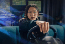 A person playing a game holding a racing sim steering wheel.